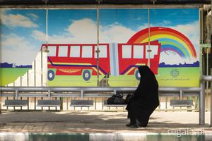 Pani w czadorze wybiera tyły tęczowego autobusu, przystanek autobusowy w Teheranie